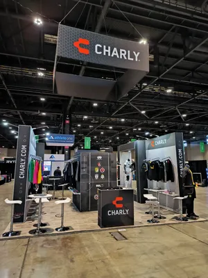 En una exposición, hay un stand de la marca Charly, parte de stand publicitario portátil