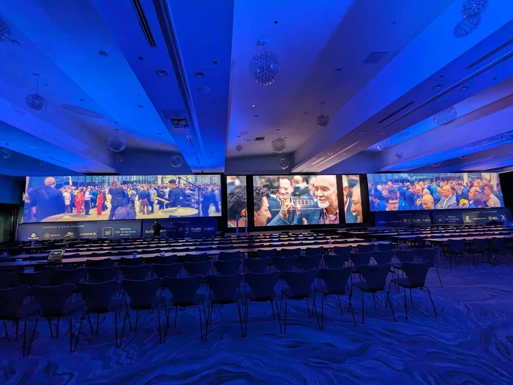 Impactante montaje de evento con tres pantallas grandes en el Radisson Blu Chicago, ideal para complementar stands para exposiciones profesionales.