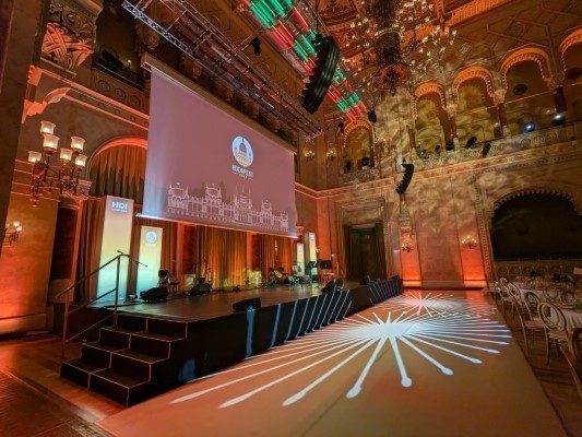 Escenario de la Feria National Restaurant Association Show con efectos de luces radiales en el Pesti Vigadó de Budapest.