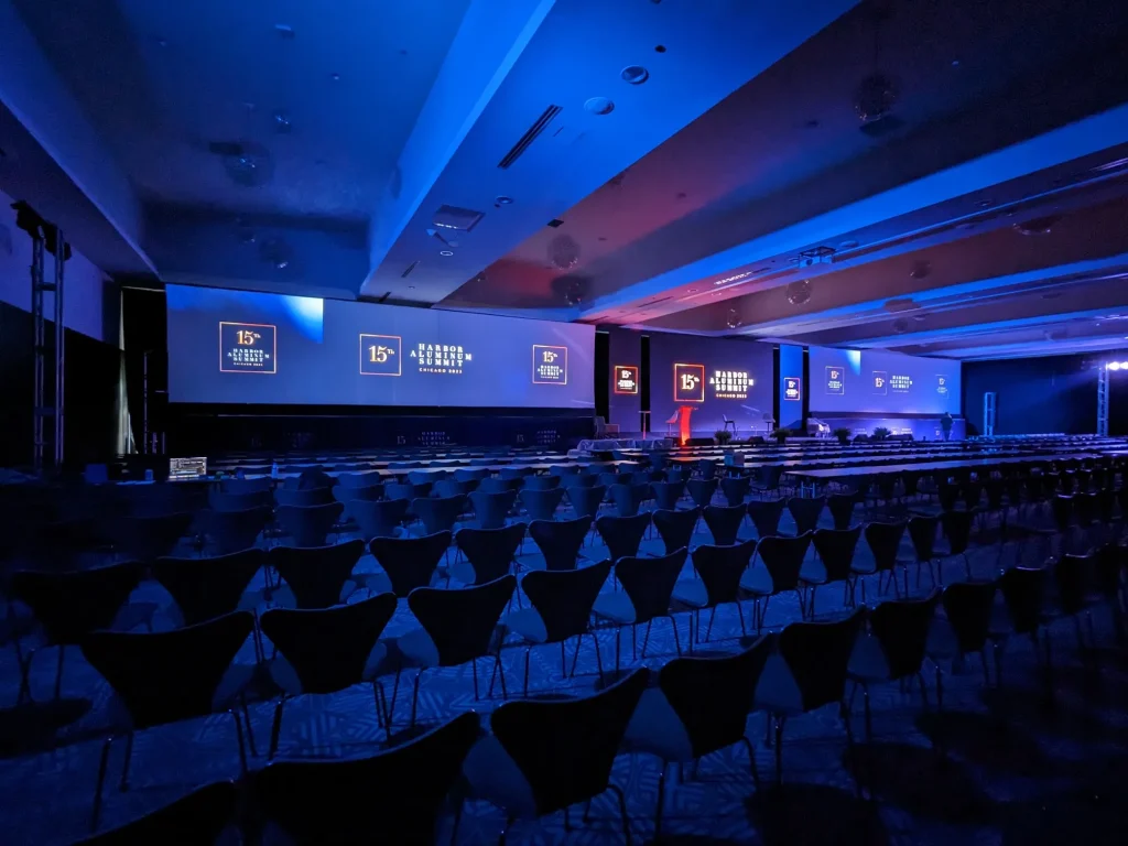 Escenario con pantallas gigantes e iluminación azul que define los nuevos stands 2026 y tendencias de stands 2026.