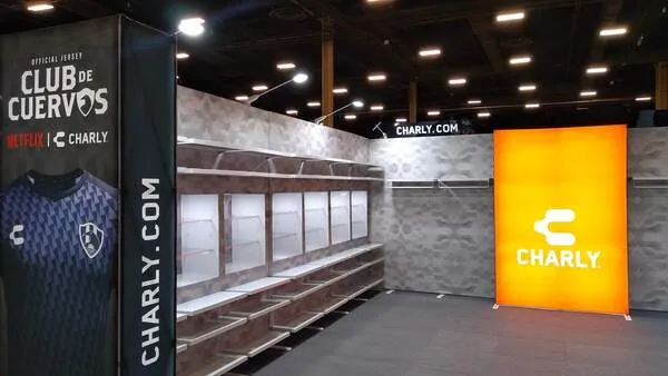 Stand de marca deportiva Charly con estantería moderna y branding de Club de Cuervos sobre cómo organizar una expo pro.