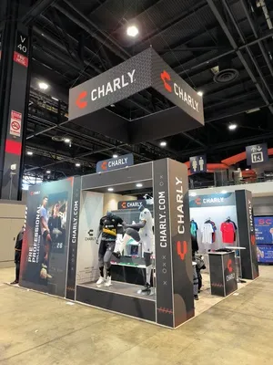 Stand de exposición de ropa deportiva con maniquíes y un letrero colgante que muestra la identidad de marca de Charly