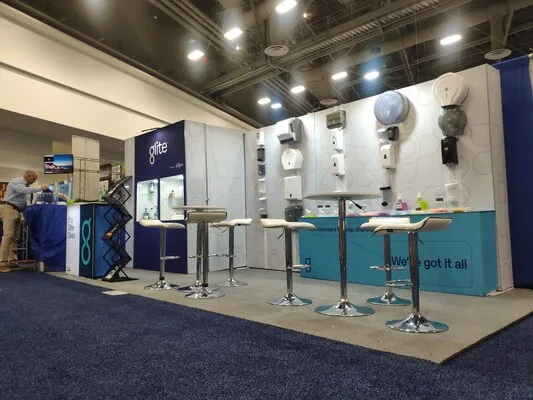 Estrategias para expos con muro de exhibición de productos y zona de networking con bancos altos.