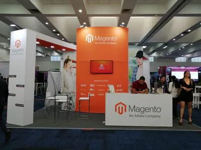 Estructura de stand Magento diseñada bajo neurodiseño con panel curvado naranja y mostradores de atención